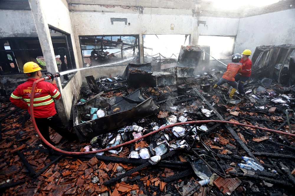 BERJIBAKU: Petugas pemadam kebakaran dan relawan menyemprotkan air ke dalam ruangan AK dan S Rumah Sakit Gatoel yang terbakar hebat Maret lalu.