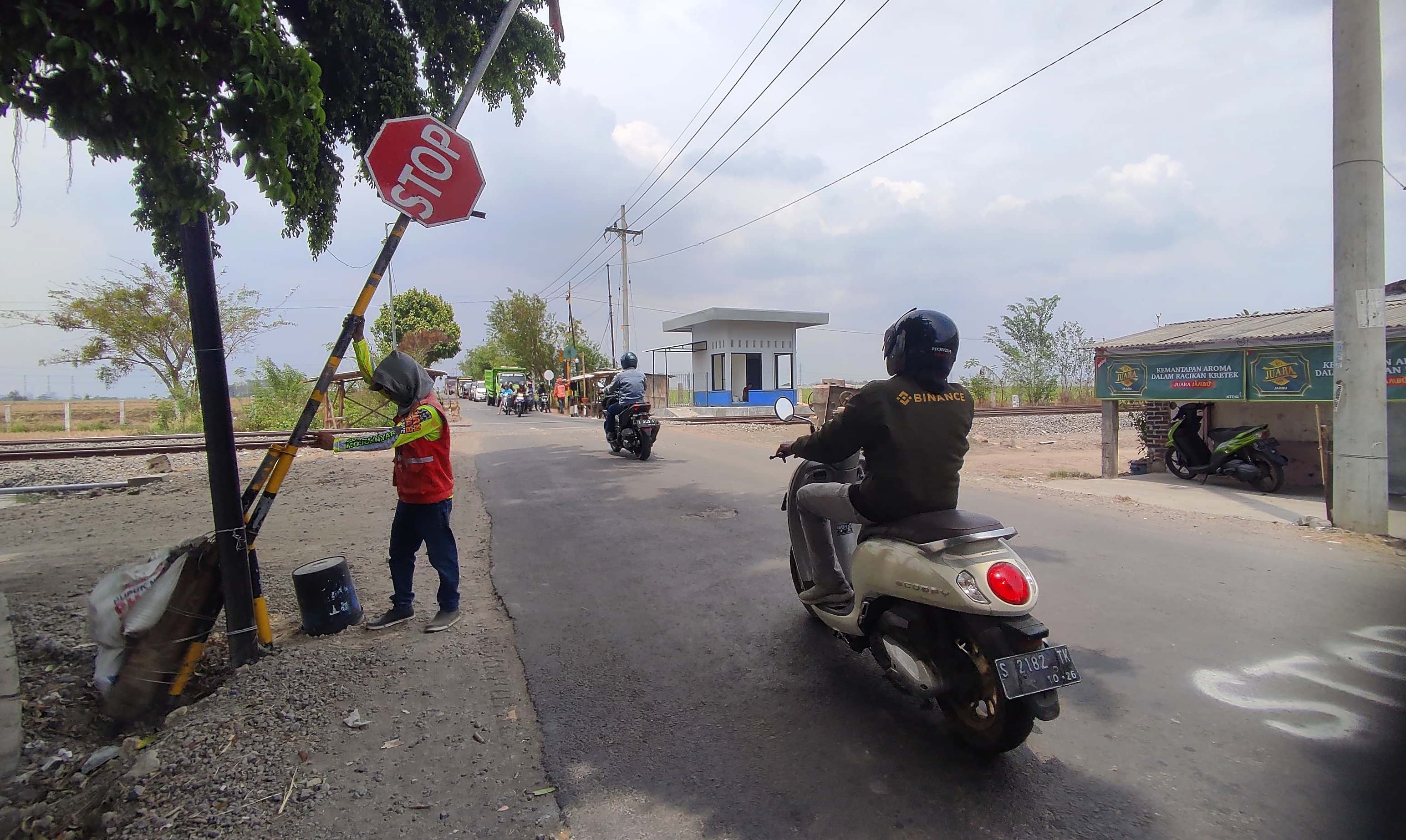 MANUAL: Relawan membuka dan menutup palang pintu darurat saat kereta api melintas di perlintasan Damarsi, Desa Kepuhanyar, Kecamatan Mojoanyar.