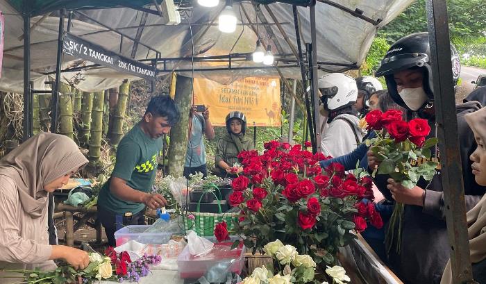 DIBIKIN ROMANTIS: Pembeli bunga segar di kawasan objek wisata Sendi, Pacet, Mojokerto sedang mengantre untuk dilayani. (foto: Moch. Chariris)