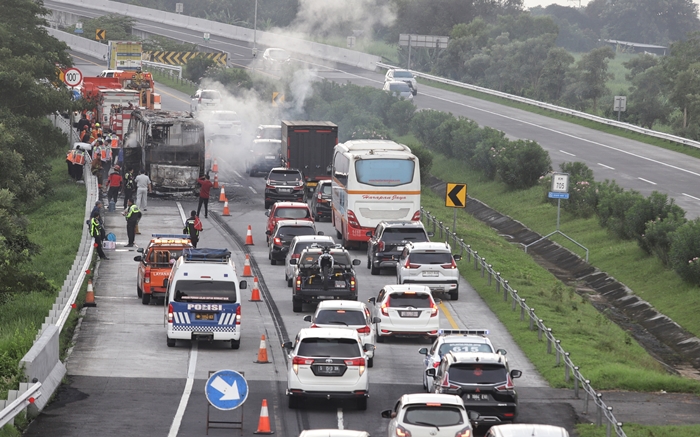 BERHASIL DIPADAMKAN: Proses pemadaman api yang membakar bus di Jalan Tol Jombang &ndash; Mojokerto KM 705 pada Rabu (17/4) pagi. (foto: Sofan Kurniawan)