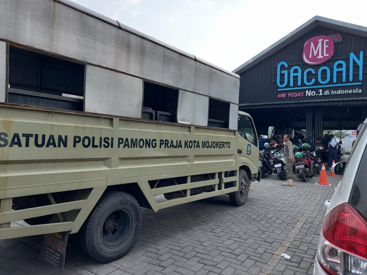 TEGAS: Petugas Satpol PP Kota Mojokerto sebelum menyegel reklame restoran Mie Gacoan di Jalan PB Sudirman, Kota Mojokerto, Selasa (16/4) petang.