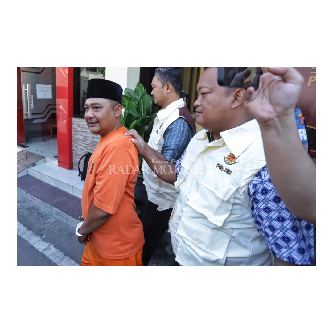 TERTANGKAP: Petugas menggelendeng Kepala Desa Sampang Agung, Ikhwan Arofidana dalam konferensi pers yang di gelar di Mapolres Mojokerto, Jumat (19/04), Kades Sampang Agung Kecamatan Kutorejo.