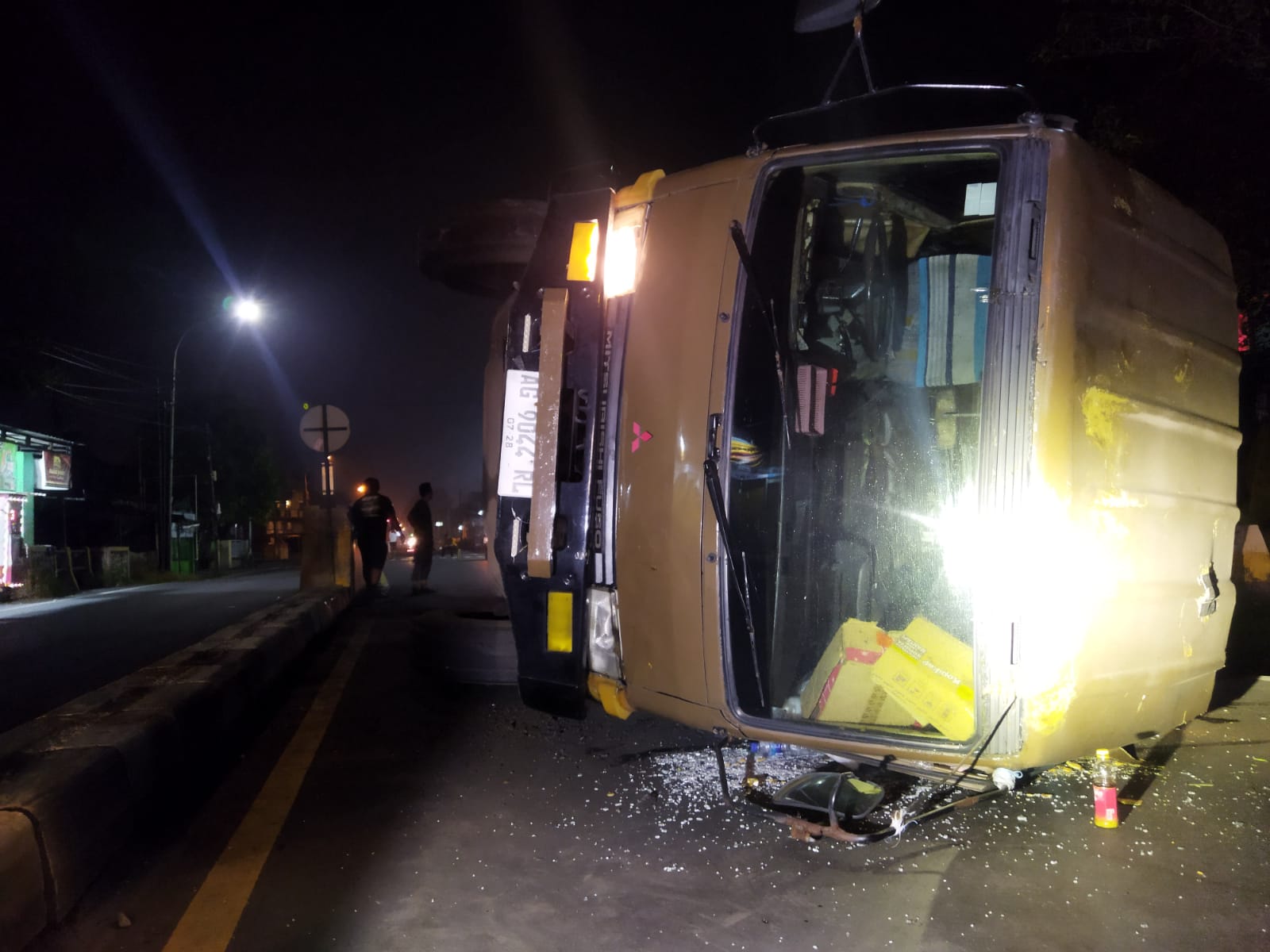 TERGULING: Truk tronton nopol AG 9044 RL muatan teh pucuk terguling usai menghantam separator jalan di depan SPN Bangsal, Rabu (24/4) dini hari.