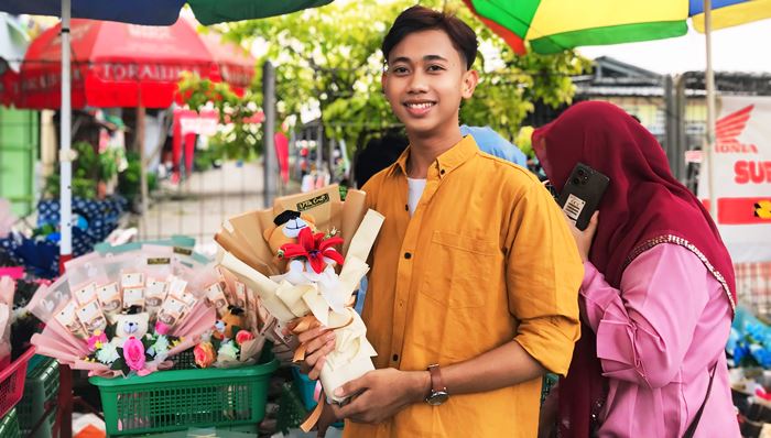 ROMANTIS: Satria Putra seorang pelajar dari Kota Mojokerto memegang buket jenis boneka yang mengingatkan Ia akan masa kecil. (foto: Nilam Mustya for Radar Mojokerto)