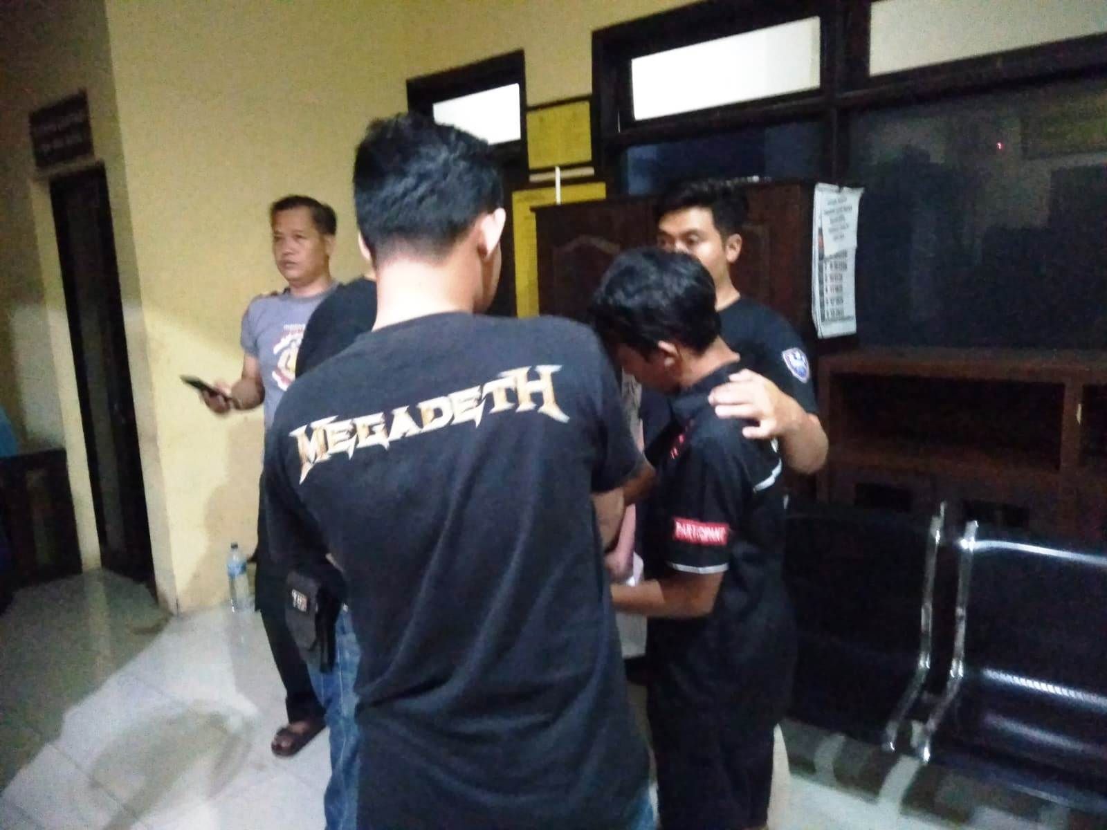 DITAHAN: RW, 19,  dikeler petugas ke rumah tahanan Mapolres Mojokerto setelah ditetapkan sebagai tersangka aksi pencabulan dan penyebar video asusila, Minggu (28/4) malam.