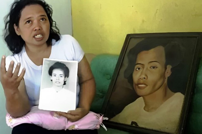 MENGENANG: Istri Widji Thukul, Siti Dyah Sujirah, memperlihatkan foto suaminya yang seorang aktivis menyuarakan hak buruh.