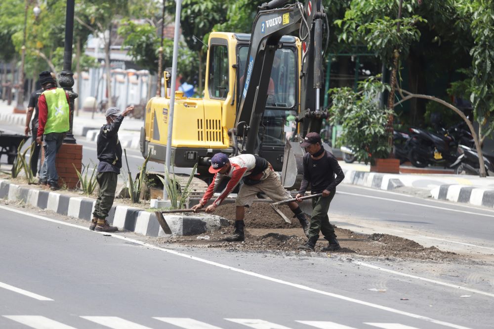 RUSAK: Petugas melakukan perbaikan jalan di ruas Jalan Empunala, Kota Mojokerto, Kamis (2/5).