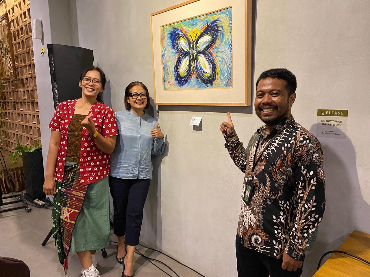 CERIA: Dwipo Hadi, kurator pameran bersama peserta di suatu sudut berhias lukisan bertemkan kupu-kupu.