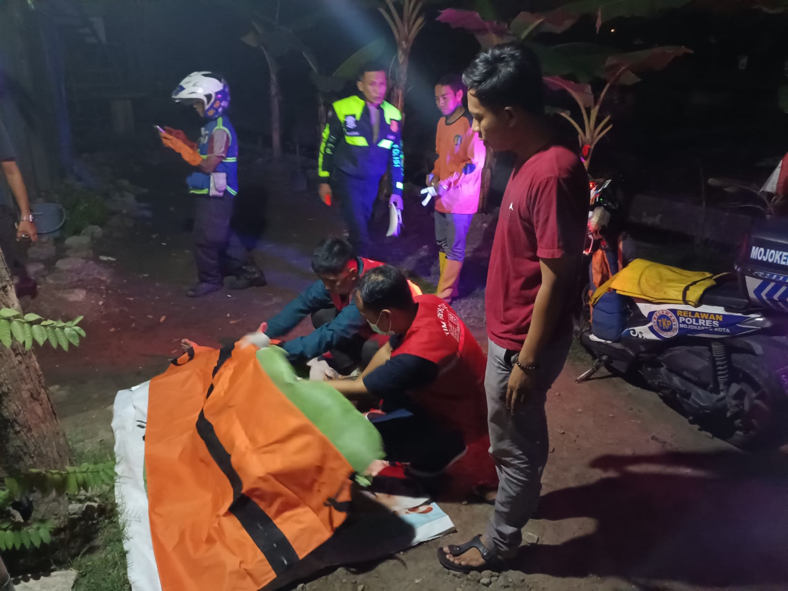 PENANGANAN: Petugas memeriksa kondisi jasad korban usai ditemukan tewas mendadak saat melintas di Jalan Raya Bypass, Kelurahan Gunung Gedangan, Kecamatan Magersari, Rabu (8/5) malam.