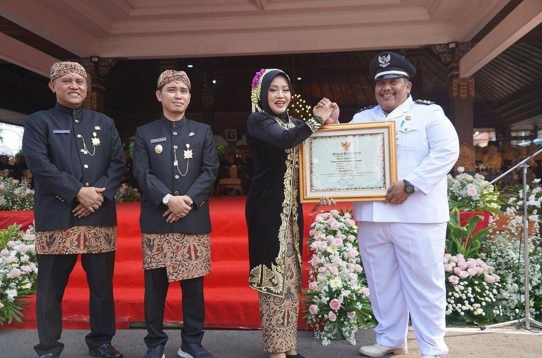 MEMBANGGAKAN: Bupati Ikfina Fahmawati menyerahkan penghargaan lunas pajak bumi dan bangunan perdesaan dan perkotaan (PBB-P2) tahun 2024 kepada Lurah Kauman Abd. Salam saat upacara Hari Jadi Ke-731.