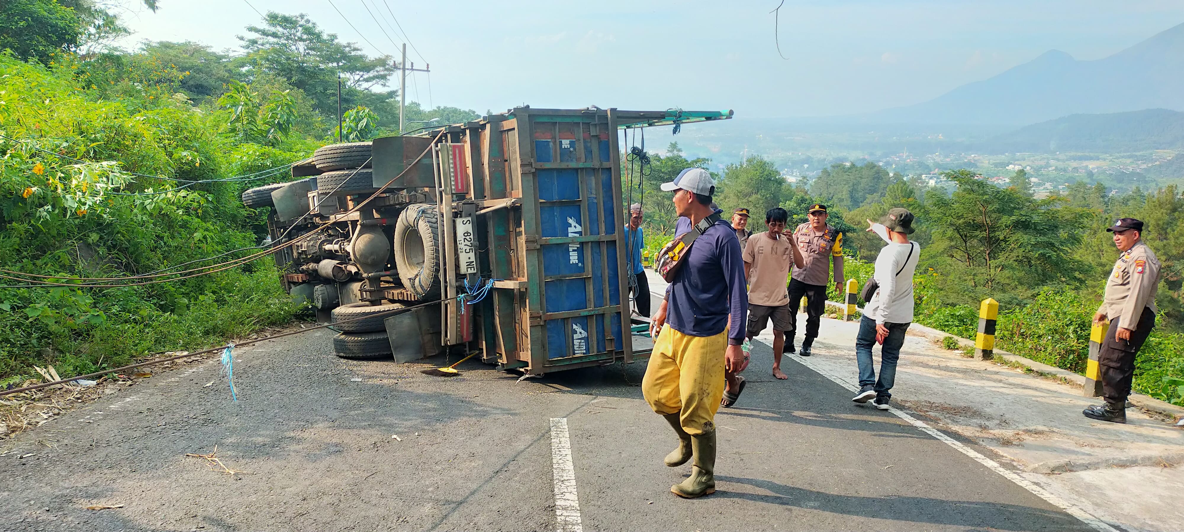 TERGULING: Truk engkel nopol S 8275 NE terguling saat melintas di turunan AMD Jalur Pacet - Cangar, Desa/Kecamatan Pacet, Mojokerto, Senin (13/5).