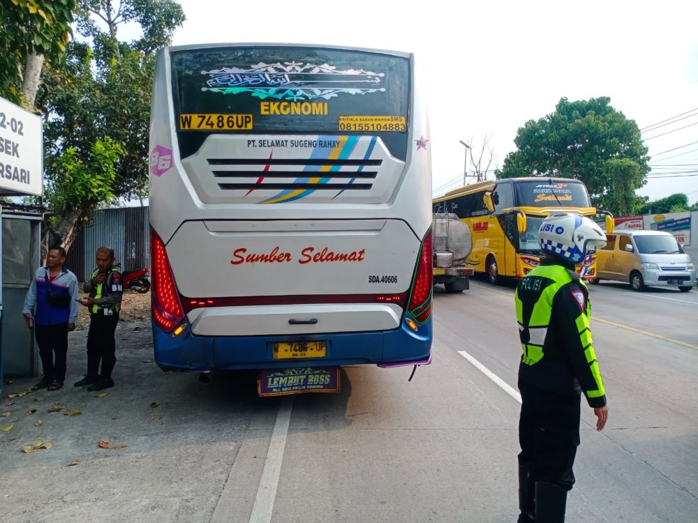 NAKAL: Petugas Satlantas Polres Mojokerto mengamankan bus Sumber Selamat yang kedapatan melewati jalur saat melintas di Jalan Raya Bypass Gunung Gedangan Kota Mojokerto kemarin.