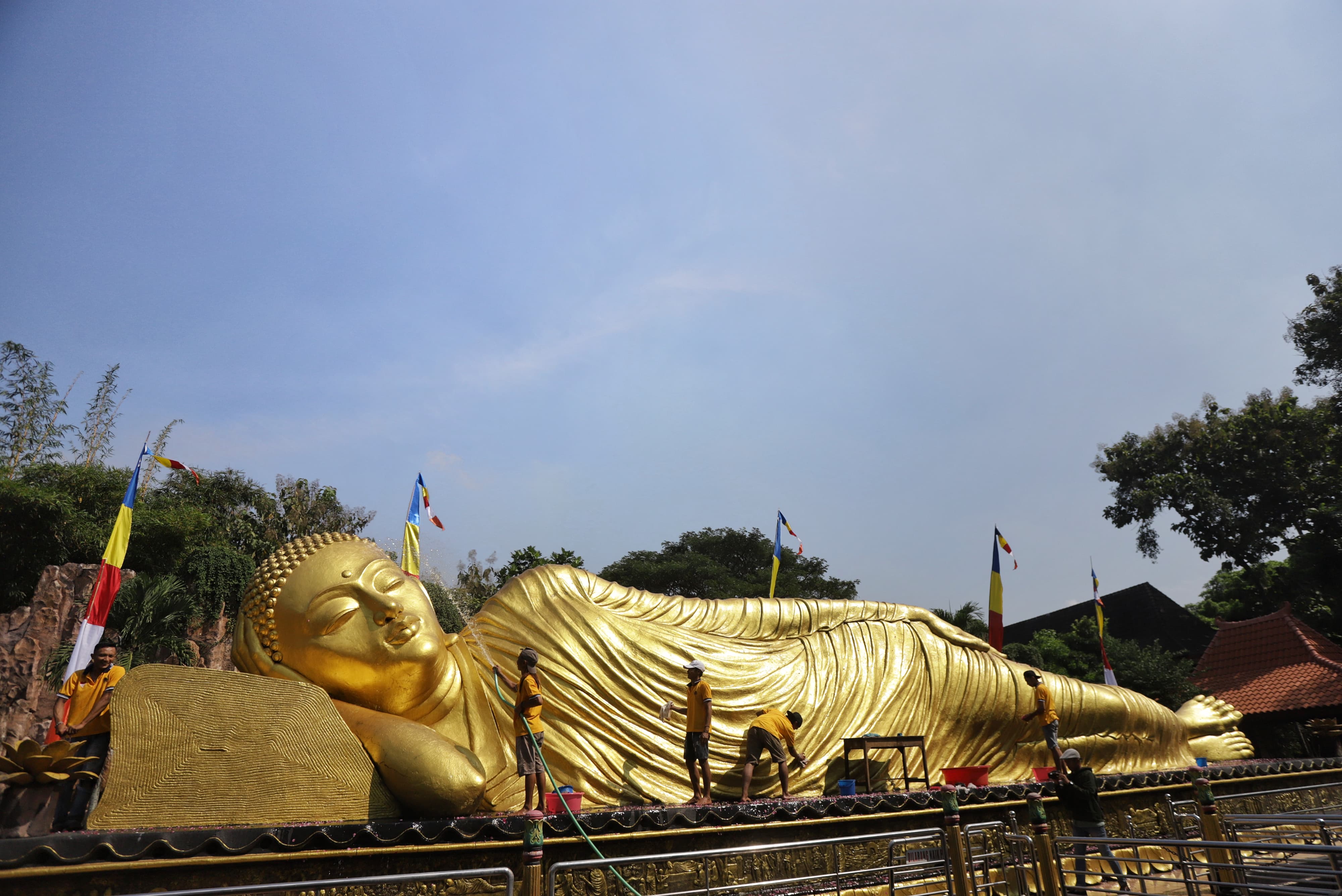PROSESI: Sejumlah orang membersihkan patung Buddha Tidur di Trowulan, Kabupaten Mojokerto sepekan menjelang Waisak, Rabu (15/5).