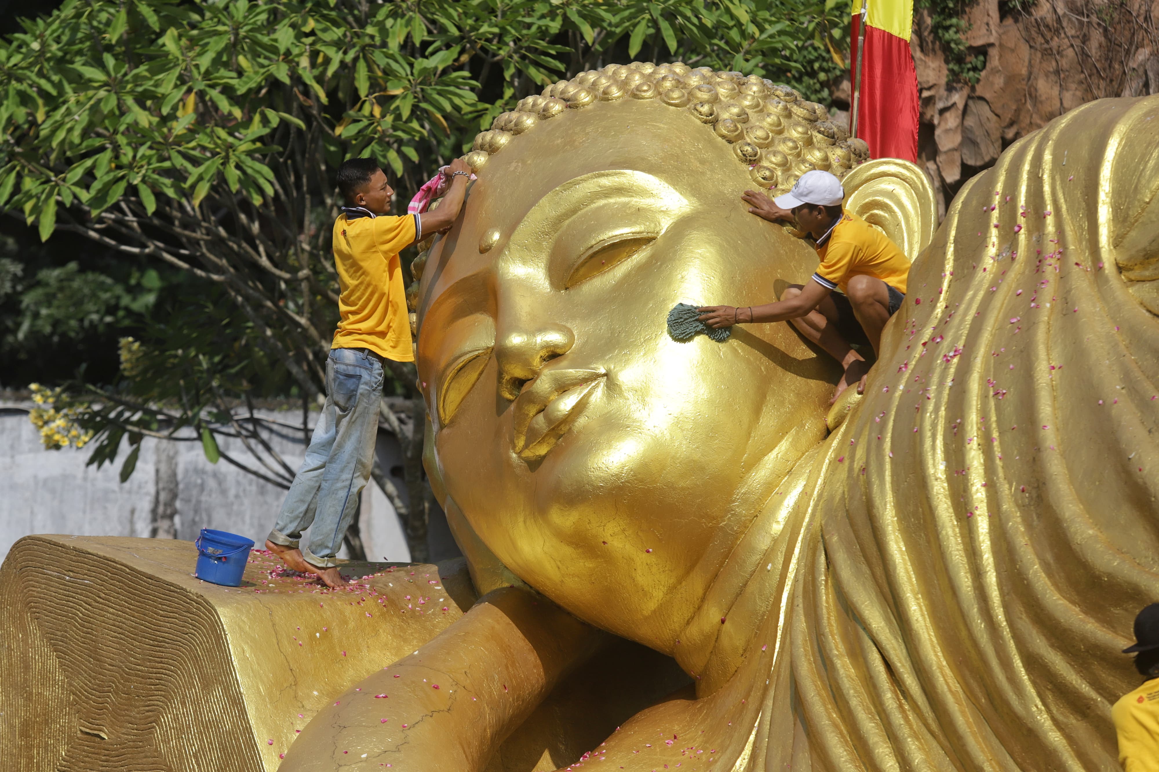 AIR MAWAR: Umat mengusap bagian kepala patung Buddha saat prosesi pensucian sebelum perayaan Waisak di Maha Vihara Majapahit Trowulan, Rabu (15/5).