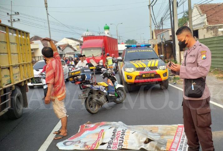 PENANGANAN: Petugas mengevakuasi jasad korban kecelakaan maut di Simpang Tiga Brangkal, Kecamatan Sooko, Minggu (26/5).
