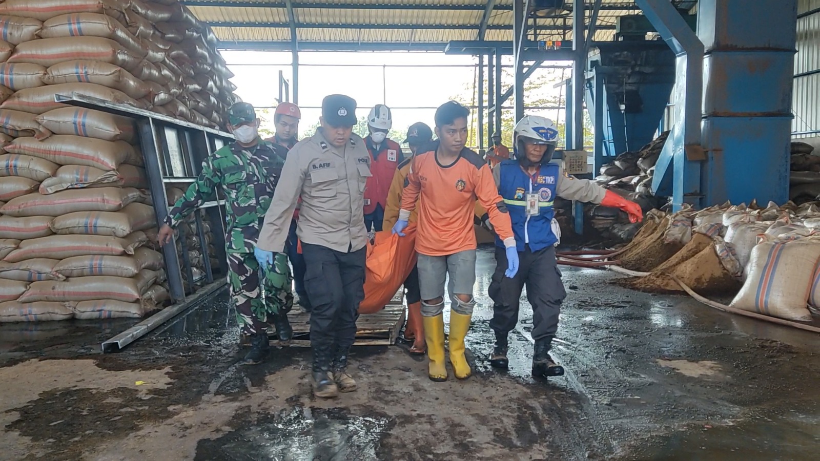 DIEVAKUASI: Petugas mengevakuasi korban kecelakaan kerja pabrik minyak kopra di Desa Perning, Kecamatan Jetis, Senin (27/5).