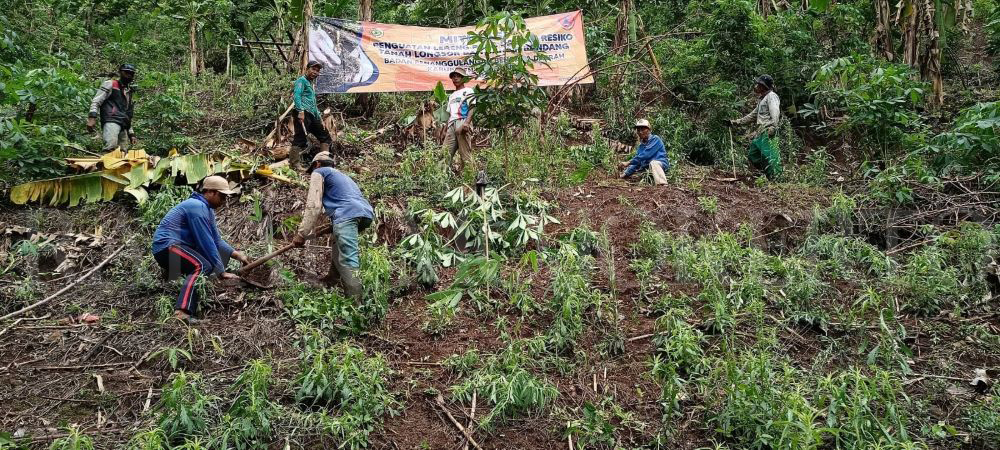 GOTONG ROYONG: Warga membersihkan tanggul Sungai Klorak yang menjadi perlintasan derasnya aliran air hujan dari atas Pegunungan Anjarmoro