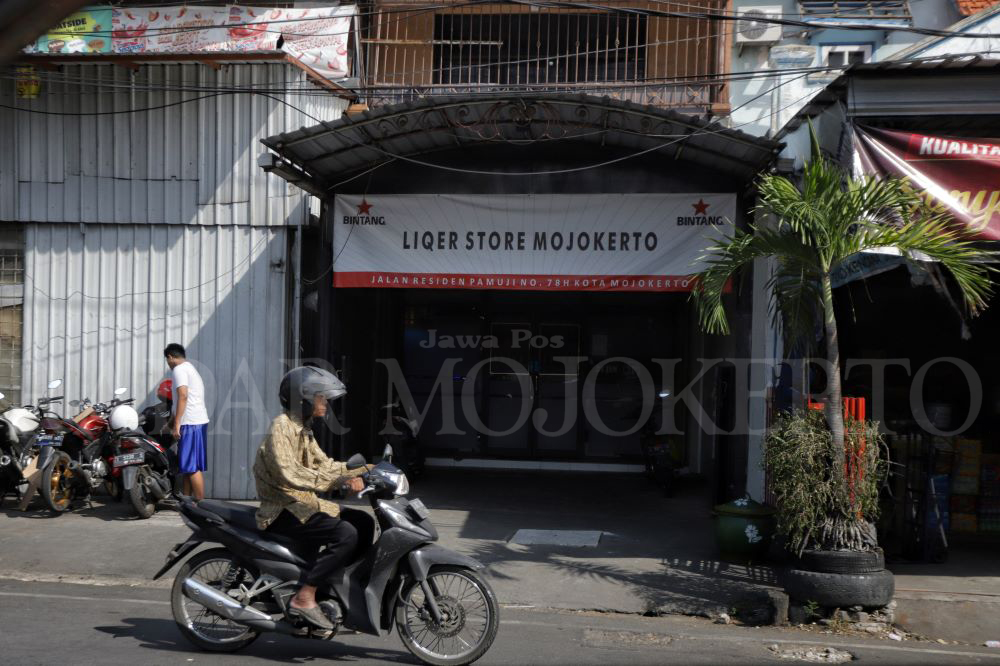 MERESAHKAN: Pengendara melintasi toko minuman beralkohol yang beroperasi di Jalan Residen Pamuji Kota Mojokerto, kemarin.