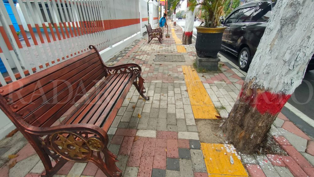 MEPET POHON: Pemasangan guiding block di proyek trotoar jalan Gajah Mada, Kota Mojokerto diduga tidak sesuai dengan pedoman perencanaan teknis fasilitas pejalan kaki, Minggu (2/6).