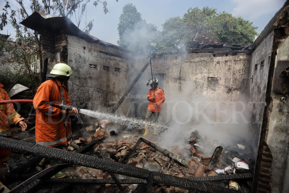 PERLENGKAPAN MINIM: Petugas Damkar Kota Mojokerto memadamkan api yang meludeskan rumah warga di Kelurahan Balongsari, Kecamatan Magersari, Rabu (5/6) siang.