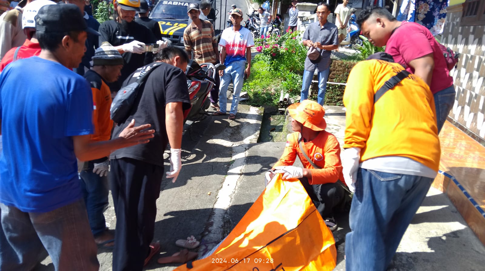 NAHAS: Petugas kepolisian dibantu relawan mengevakuasi jasad korban kecelakaan maut di Jalan Raya Desa Jatijejer, Kecamatan Trawas, Senin (17/6) pagi.