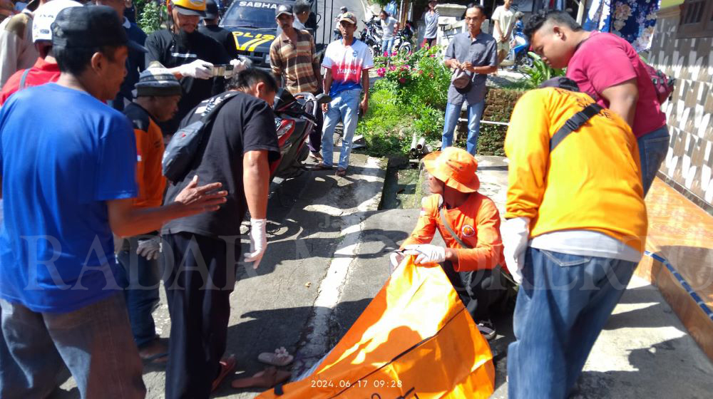 DIEVAKUASI: Petugas kepolisian dibantu relawan mengevakuasi jasad korban kecelakaan maut di Jalan Raya Desa Jatijejer, Kecamatan Trawas, kemarin (17/6).