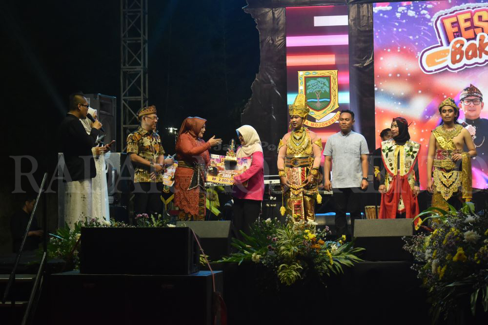 BANGGA: Kepala SMPN 8 Mojokerto Siti Nuryati terima piala dan trofi usia dinyatakan menang sebagai peringkat pertama kostum terbaik, Senin (17/6).