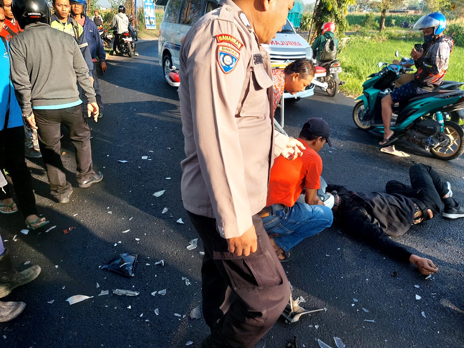 TERKAPAR: Petugas kepolisian bersama tim medis Puskesmas Puri menolong korban kecelakaan di Jalan Raya Desa Tangunan, Kecamatan Puri, Kamis (27/6) pagi.