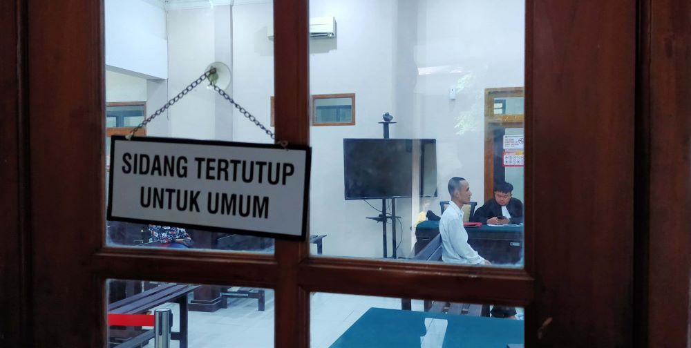 TERTUTUP: Abdul Khamim, 29, melakoni sidang perdana agenda dakwaan secara tertutup di Pengadilan Negeri Mojokerto, Senin (1/7).