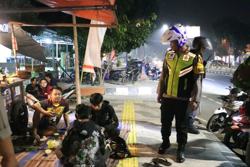 AGAR AMAN: Wakapolres Mojokerto Kota Kompol Supriyono mengecek situasi salah satu angkringan di Jalan Empunala, Selasa (2/7) malam.