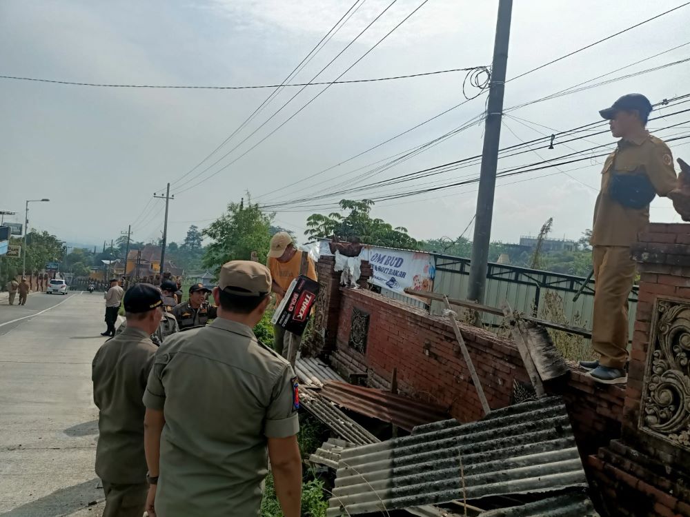 TAK BERIZIN: Petugas Satpol PP Kabupaten Mojokerto membongkar bangunan liar yang digunakan untuk menjajakan sewa penginapan di kawasan wisata Desa Padusan, Kecamatan Pacet, Mojokerto.