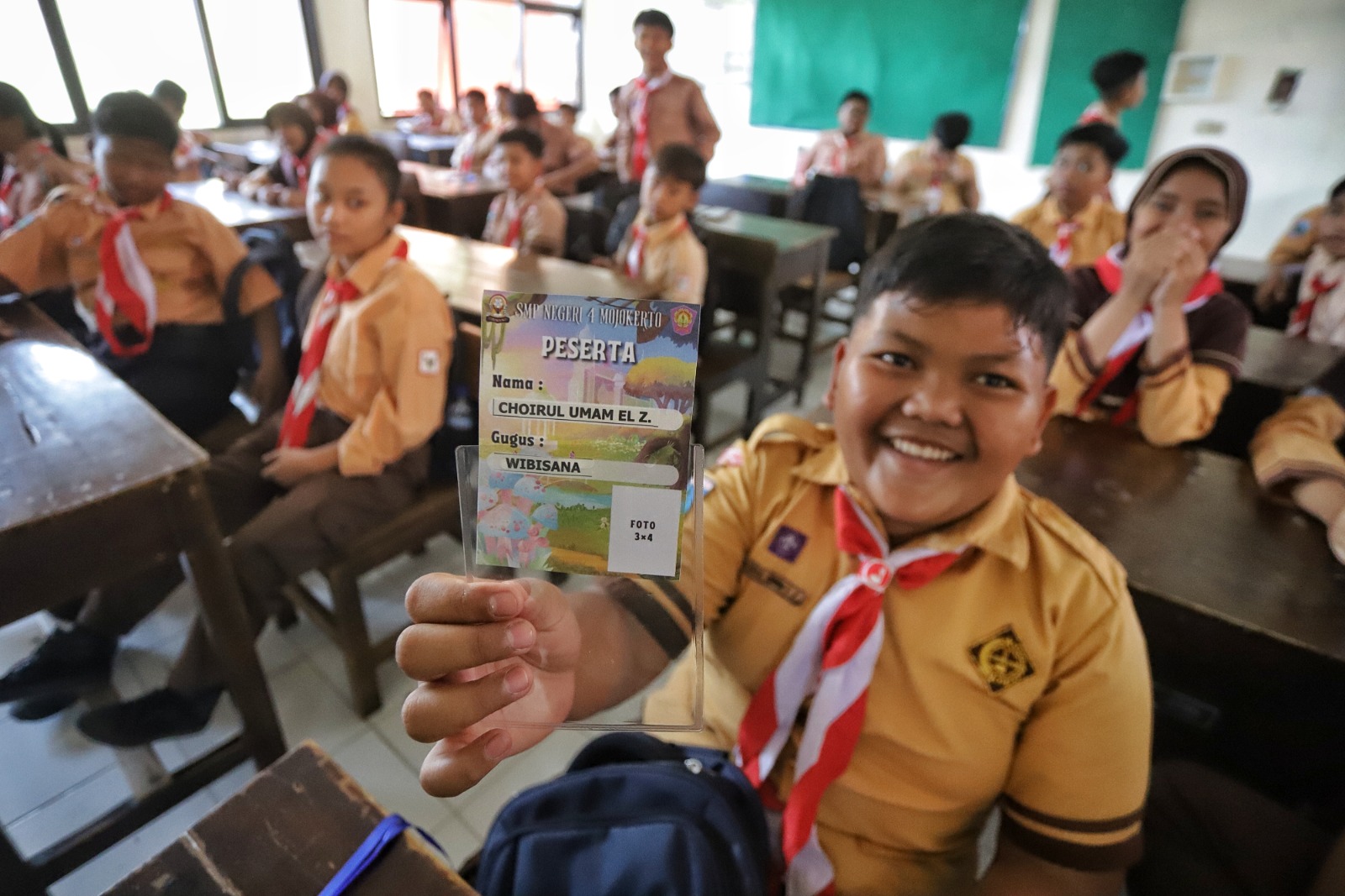 PERDANA: Peserta didik baru SMPN 4 Mojokerto menerima ID card yang akan dipakai saat pelaksanaan MPLS pada Senin (15/7).