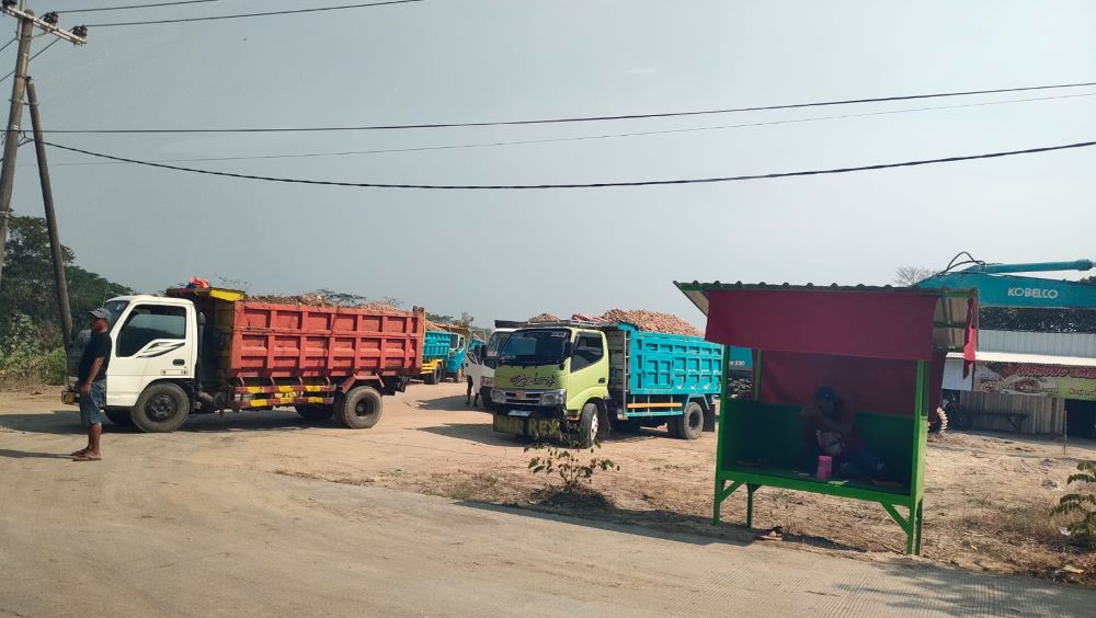 DIKELUHKAN: Sejumlah truk pengakut material galian C keluar masuk di area tambang yang diduga ilegal, di Desa Sidorejo, Kecamatan Jetis.