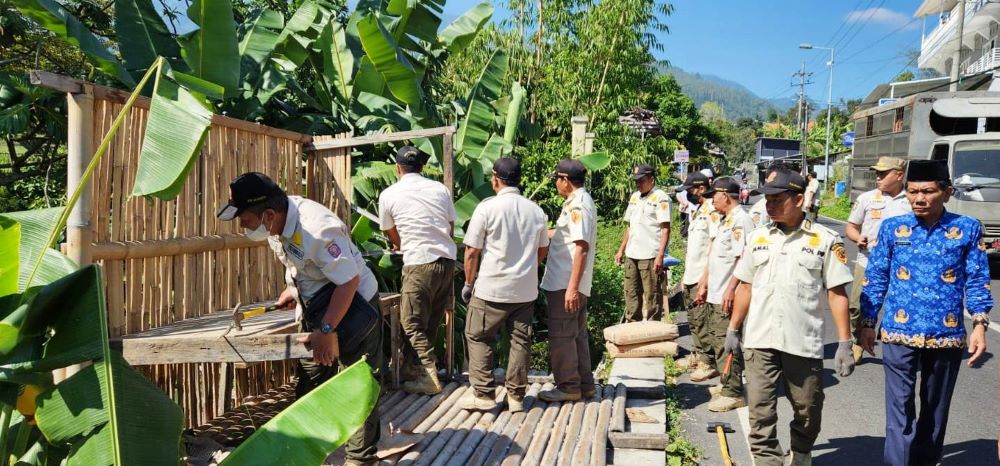JADI PERHATIAN: Petugas menertibkan bangli di tepi jalur Wanawisata Air Panas Padusan, Desa Padusan, Kecamatan Pacet, Rabu (17/7).