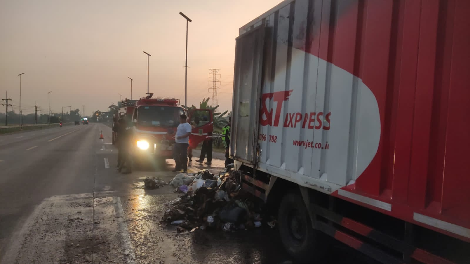 TAK TERSELAMATKAN: Petugas pemadam kebakaran Pemkot Mojokerto berjibaku memadamkan api di dalam boks truk jasa ekspedisi di Jalan Raya Bypass, Kelurahan Gunung Gedangan, Kota Mojokerto.