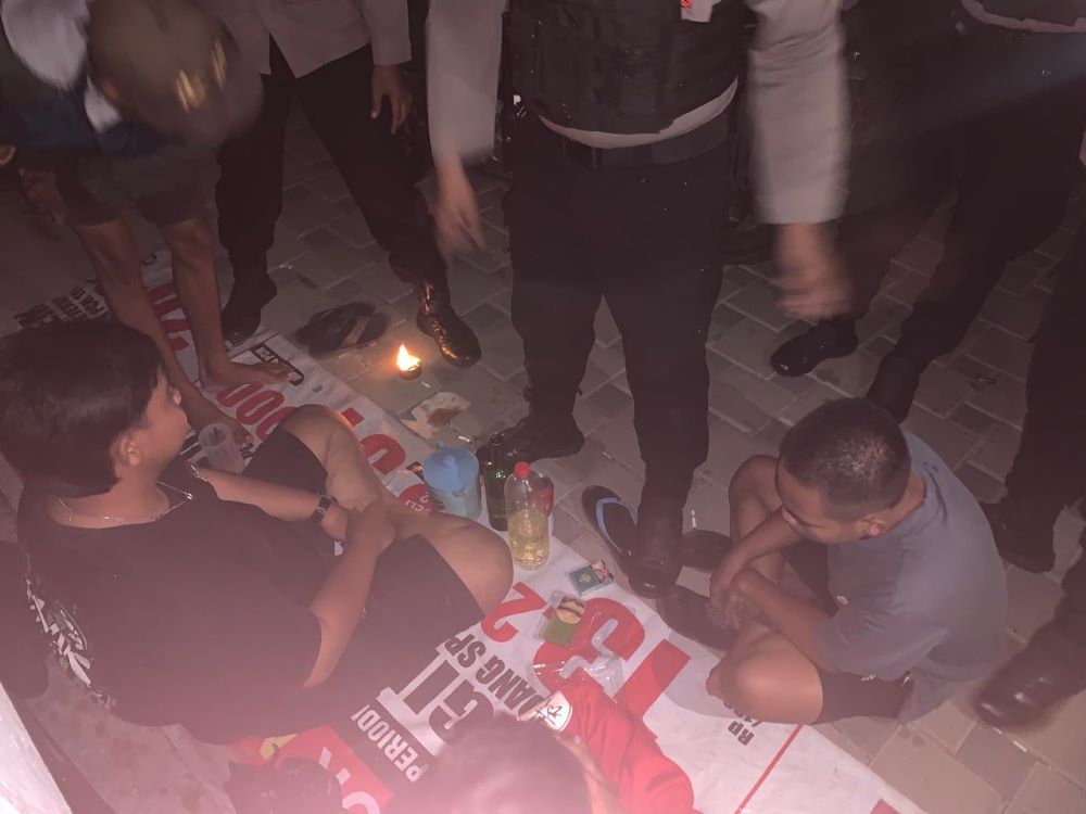 TAK BERKUTIK: Petugas Satsamapta Polres Mojokerto Kota memeriksa empat pemuda yang kedapatan pesta miras di Jalan Ir. Soekarno dekat Taman Bahari Majapahit, kompleks jembatan Rejoto, Sabtu (27/7).