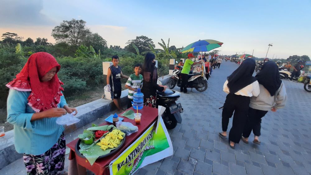 MASIH BERTAHAN: Suasana ruas Jalan Ir. Soekarno yang tetap dipenuhi pedagang dan pengunjung di hari terakhir surat peringatan yang diedarkan Satpol PP Kota Mojokerto, Selasa (30/7) sore.