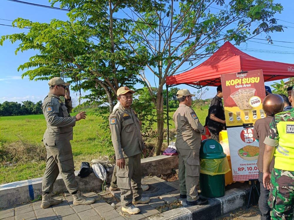 DIPANTAU: Petugas Satpol PP Kota Mojokerto bersama personel gabungan melakukan patroli untuk memastikan tidak ada PKL yang kembali membuka lapak di ruas Jalan Ir Soekarno, kemarin (1/8).