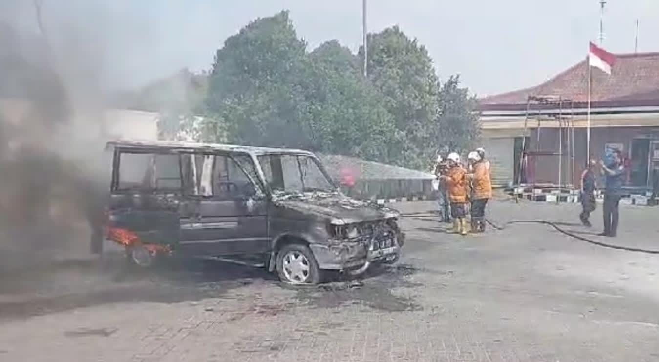 PEMADAMAN: Petugas damkar memdamkan api yang membakar satu unit mobil Toyota Kijang di SPBU Pertamina 54.613.11 Ngrowo, Kecanatan Bangsal, Mojokerto, Kamis (8/8).