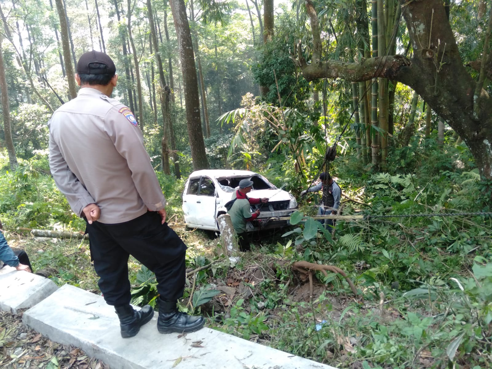 DIKATROL: Petugas Polsek Pacet bersama warga mengevakuasi mobil Nissan Grand Livina nopol AD 1761 NH yang terperosok di jurang turunan AMD, Desa/Kecamatan Pacet, Mojokerto, Senin (12/8).