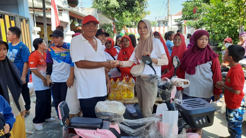 APRESIASI: Ketua DPRD Kota Mojokerto Sunarto menyerahkan doorprize sepeda listrik kepada peserta jalan sehat memperingati HUT Ke-79 Kemerdekaan RI, Minggu (18/8).