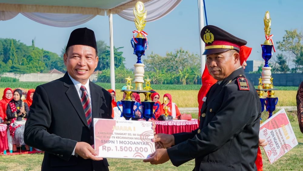 APRESIASI: Kepala SMPN 1 Mojoanyar Sugito menerima hadiah juara pertama lomba karnaval.