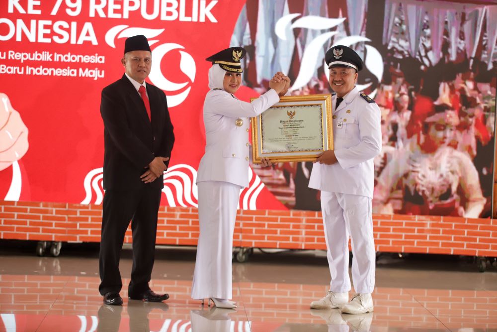 BENTUK APRESIASI: Bupati Mojokerto Ikfina Fahmawati didampingi Sekdakab Teguh Gunarko, menyerahkan hadiah kepada para kades dan lurah yang berhasil membawa desanya lunas PBB P2, di Pendapa.