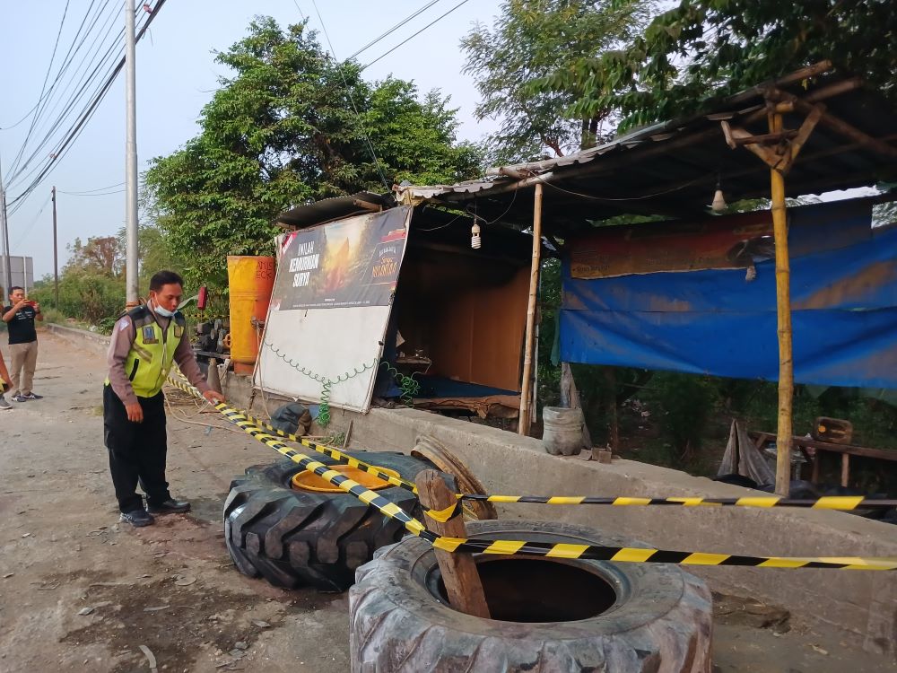 PASCA LEDAKAN: Polisi memasang garis pengaman di tambal ban yang meledak di Jalan Raya Desa Mlirip, Kecamatan Jetis kemarin (21/8) petang.