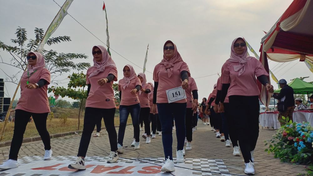 ANTUSIAS: Peserta dari tim TP PKK Dosremo antusias mengikuti gerak jalan yang digelar Kecamatan Pungging, kemarin (22/8).