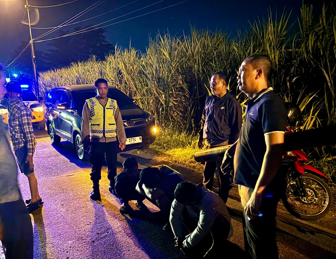 MERESAHKAN: Ketiga pelaku jongkok meringkuk setElah diamankan petugas Polsek Pungging di tepi Jalan Raya Desa Kalipuro, Kecamatan Pungging.