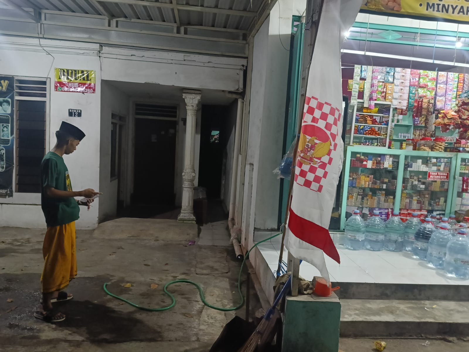 LOKASI PENCURIAN: Rahman, 20, menunjukkan tempat semula motor miliknya terparkir di teras samping toko.