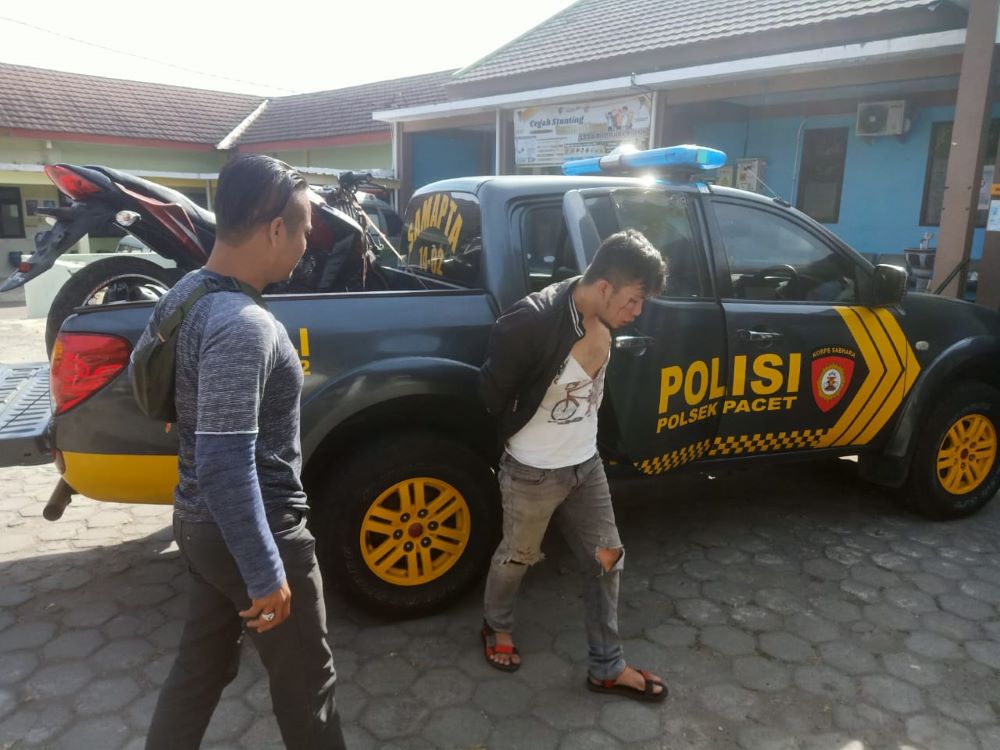 TAK BERKUTIK: Regen, 29, dikeler petugas kepolisian ke puskesmas sebelum diproses di Mapolsek Pacet, Selasa (27/8) pagi.