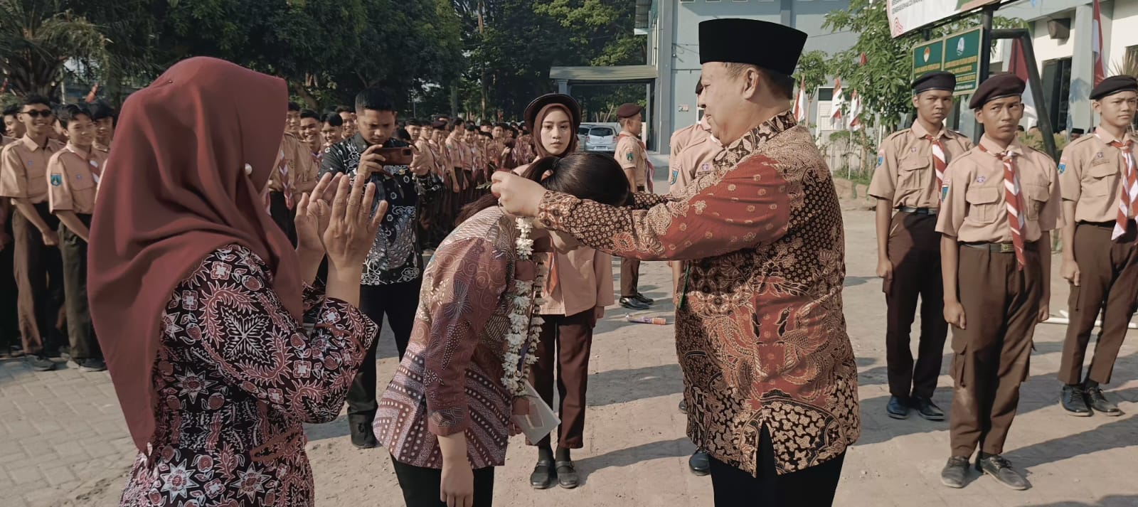 SELAMAT DATANG: Kepala MAN 2 Mojokerto Rahmad Basuki&nbsp; mengalungkan bunga kepada Fujita Sensei.