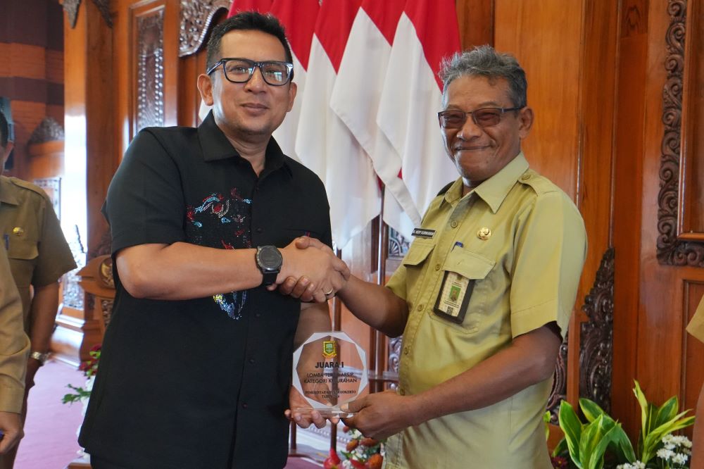 PRESTASI: Pj Wali Kota Mojokerto Moh. Ali Kuncoro menyerahkan piagam juara I ajang Tertib Arsip 2024 kategori kelurahan kepada Lurah Mentikan M. Hery Kurniawan.